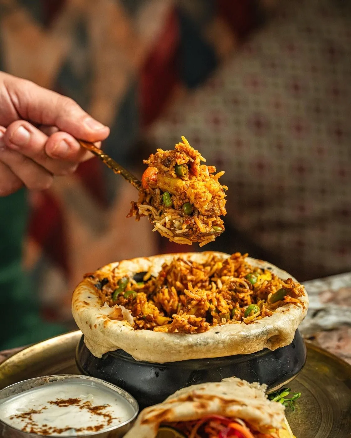 Main qui dépose une garniture sur un plat, vue de dessus
