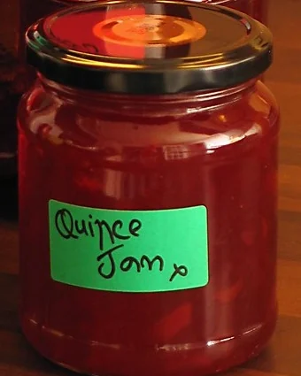 La photo de départ : un pot de confiture de coings, son étiquette verte écrite à la main : Quince Jam