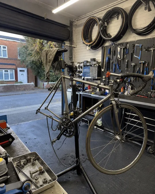 Photo de départ : vélociste, arc lent vers la droite autour du vélo posé sur le pied d'atelier, chaîne démontée